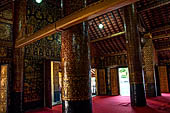 Wat Xieng Thong temple in Luang Prabang, Laos. The sim s interior is extensively decorated with intricate gold stencilling on black lacquer. Large stencilled teak wood pillars support the roof.  